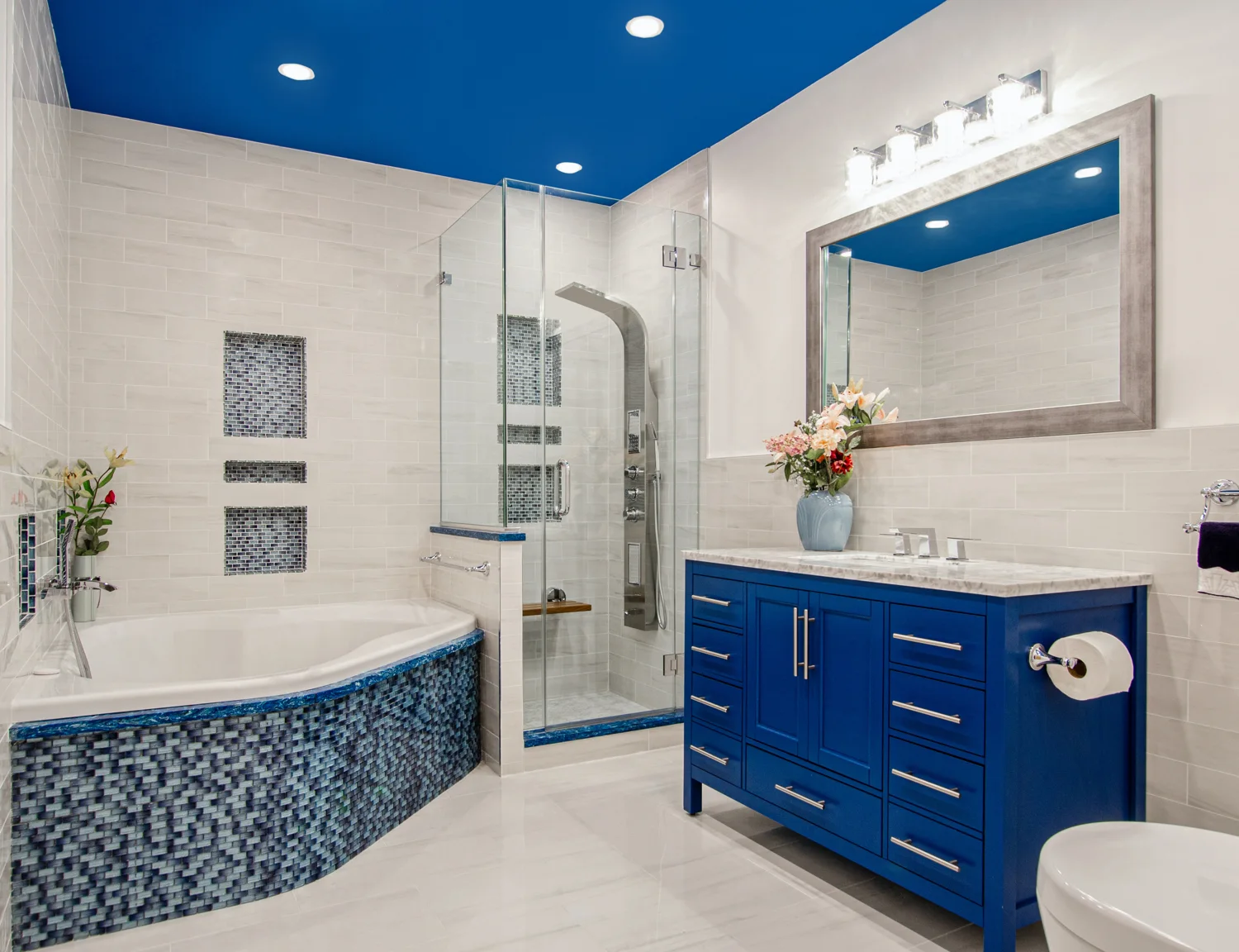 Illustrative bathroom with a glass shower, tub and blue vanity